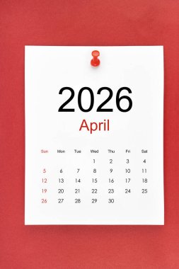 Nisan 2026 takvim sayfası kırmızı zemin üzerinde pin basın.