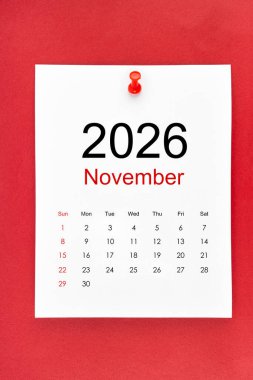 Kasım 2026 takvim sayfası kırmızı zemin üzerinde pin basın.
