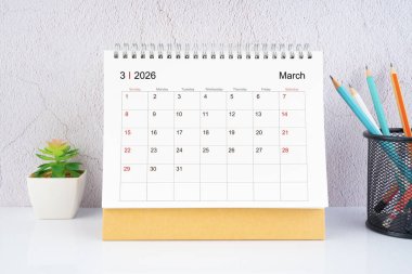 Masanın üzerinde tahta kalemle Mart 2026 Masa Takvimi.