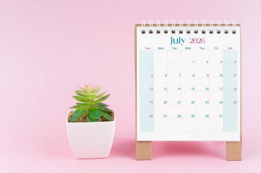 Temmuz 2026 tarihli masa takvimi. Pembe arka planda saksı var..