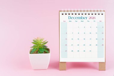 Aralık 2026 tarihli masa takvimi. Pembe arka planda saksı var..