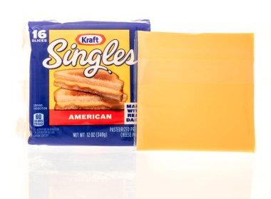 Winneconne, WI - 8 Ekim 2023: Bir paket Kraft, izole bir arkaplanda Amerikan peynirini dilimliyor