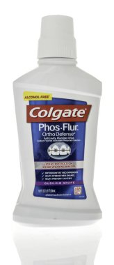 Winneconne, WI - 23 Aralık 2023: Bir şişe Colgate Phos Flur ortopedi savunması izole bir arkaplanda diş teli kullanırken ideal koruma.