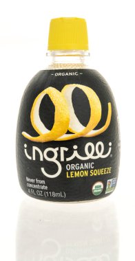 Winneconne, WI - 26 Nisan 2024: Bir şişe ingrilli organik limon izole edilmiş arka planda sıkışıyor.