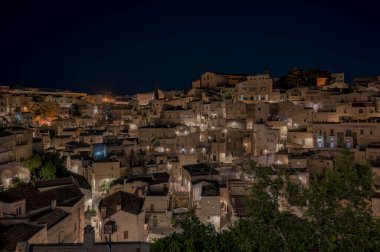 Gece canlı bir şehrin bulanık ve belirsiz bir resmi, çeşitli binaları süsleyen birçok parıltılı ışık sergiliyor.