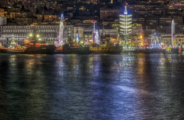 Bu bulanık ya da belirsiz bir görüntü, gece saatlerinde hareketli bir şehrin ön planda belirgin bir şekilde bulunan büyük bir su kütlesini resmediyor.