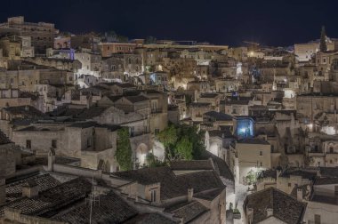 Matera 'nın çarpıcı hava gece manzarasını deneyin, tarihi mimarisini ve çekiciliğini vurgulayın.