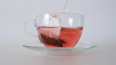 Bardaktaki çay poşetinin üzerine kaynar su dök.