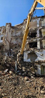 Binanın yıkımı. Kazıcı eski evi yıkıyor. Uzun silahlı yıkım makinesi bir binayı yıkarken görüldü.