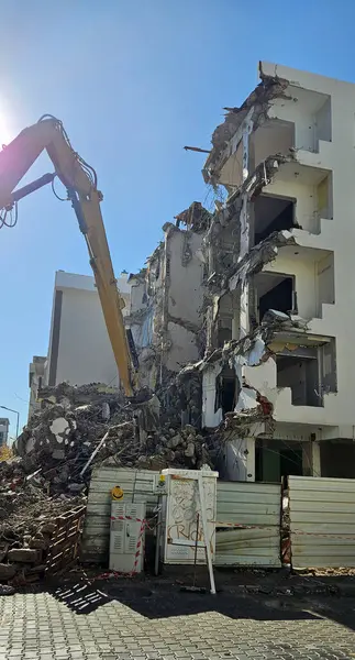 Binanın yıkımı. Kazıcı eski evi yıkıyor. Uzun silahlı yıkım makinesi bir binayı yıkarken görüldü.