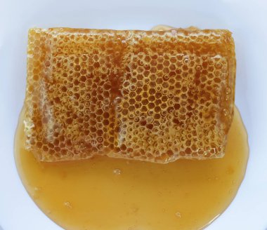 Bal, bal peteğinin üzerinden akıyor.