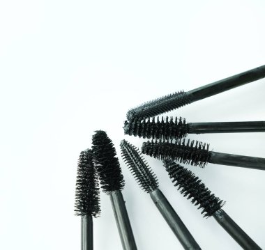 Beyaz arkaplanda çeşitli rimel fırçaları