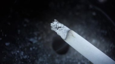 Siyah arkaplanda sigara dumanı olan sigara manzarasını kapat