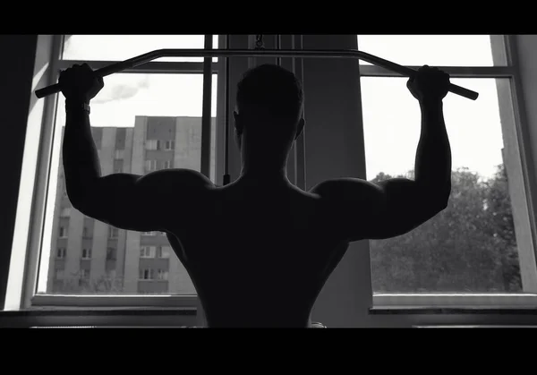 肌肉男在健身房锻炼 有创意的照片 黑白照片 肌肉轮廓 美丽的身体 性感的小伙子 — 图库照片