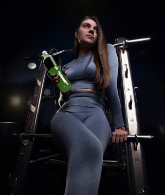 Spor yapan güçlü bir kadın. Spor yaşam tarzı. Güzel kadın dambılları kaldırıyor. Sporcu kadın iyi eğitilmiş vücudunu gösteriyor. Güzel bir kız vücudu ve dalgalı kasları.