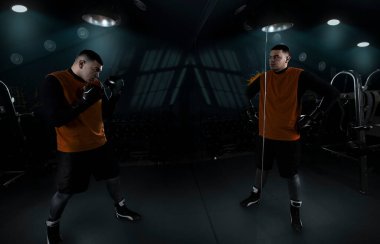 Sporcu boksör, kendini aynanın karşısına koyup antrenman yapar. Kavganın beklentisinde yansıması ile başarıya emin bir şekilde hazırlanır. Yorgun ve güçlü yaratıcı bir fotoğraf. Yüksek kalite