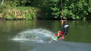 Göl kenarındaki Wakeboardcu Temmuz 2021 'de Ukrayna' daki Zhytomer 'de kalmak üzere trenlere biner. Olağanüstü bir spor. Suya doğru kay. Yüksek kaliteli HD görüntüler