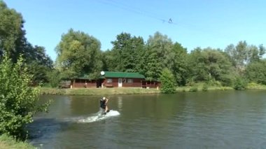Göl kenarındaki Wakeboardcu Temmuz 2021 'de Ukrayna' daki Zhytomer 'de kalmak üzere trenlere biner. Olağanüstü bir spor. Suya doğru kay. Yüksek kaliteli HD görüntüler