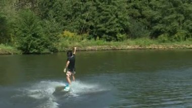 Göl kenarındaki Wakeboardcu Temmuz 2021 'de Ukrayna' daki Zhytomer 'de kalmak üzere trenlere biner. Olağanüstü bir spor. Suya doğru kay. Yüksek kaliteli HD görüntüler