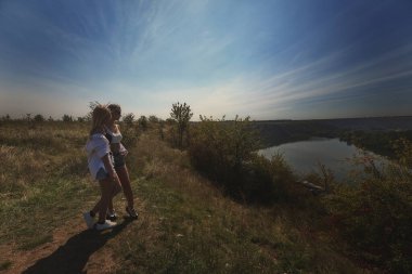  En iyi iki arkadaş işe ara verir, rahat hisseder ve mahremiyetin tadını çıkarırlar. Doğadaki sarışın kız kardeşler manzaraya bakarlar. Yaz ve güzel hava. Yüksek kalite fotoğraf