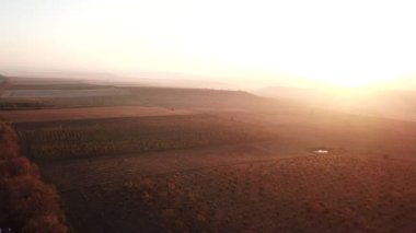 Akşam portakal rengi bir günbatımında yüksekten yavaş, dramatik bir masal videosu. Yüksek kalite 4k görüntü