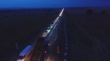 Gece vardiyası. 48 saat. Gece trafiği. Asfalt kaldırım taşı, paten ve kamyon asfaltlama sırasında tamir sahasında. Yol yapım ekipmanları. İşçiler tamir ediyor. Karayolu yakınında kamyonlar çalışıyor. Arabalar