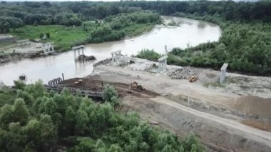 Construction site of a bridge across the road . Bird eye. big faucet. Aerial view of the construction of the bridge. Aerial view of the infrastructure flyover across the river. High quality FullHD