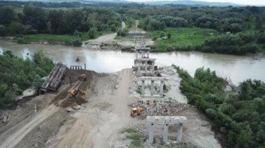Construction site of a bridge across the road . Bird eye. big faucet. Aerial view of the construction of the bridge. Aerial view of the infrastructure flyover across the river. High quality FullHD