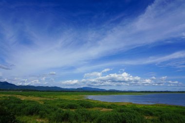 Barajın sonundaki güzel alan açık bir günde ve sadece yeşil ağaçlara karşı parçalı bulutlu..