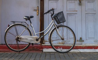 Evin önüne park etmiş bir sepetli kadının bisikleti..