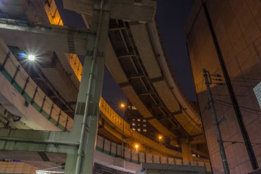 Night view with long-exposure starburst effects, of the complex Hakozaki Junction on the Shuto Expressway in Chuo CIty, Tokyo, Japan, looking upwards from street level.