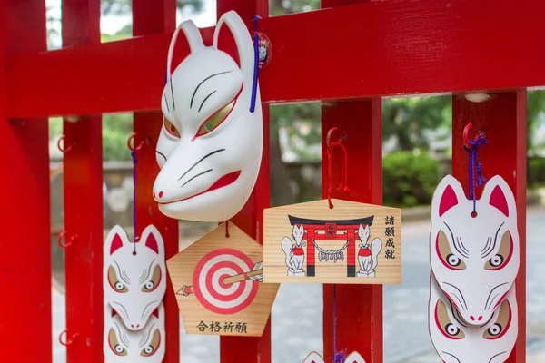 Red and white fox masks and ema prayer plaques at Asanogawa inari jinja, Kanazawa, Japan.