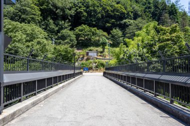 Saigawa Nehri üzerindeki Kumabashiri Köprüsü, Komagaerimachi, Ishikawa, Japonya. Parmaklıklar ve dikenli teller intihar girişimlerini engellemek için..