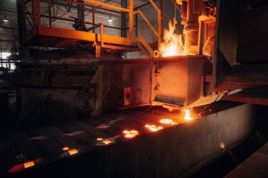 Dökümhanede döküm kalıplarına erimiş metal dökülüyor.