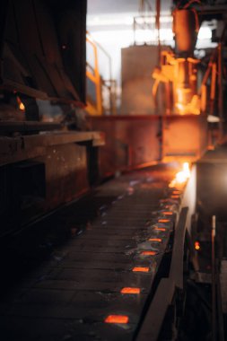 Erimiş metal, bir metal fabrikasındaki taşıyıcı bant boyunca akar.