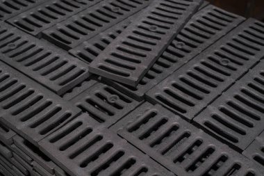 Bir yığın koyu gri drenaj ızgarası kurulmaya hazır.