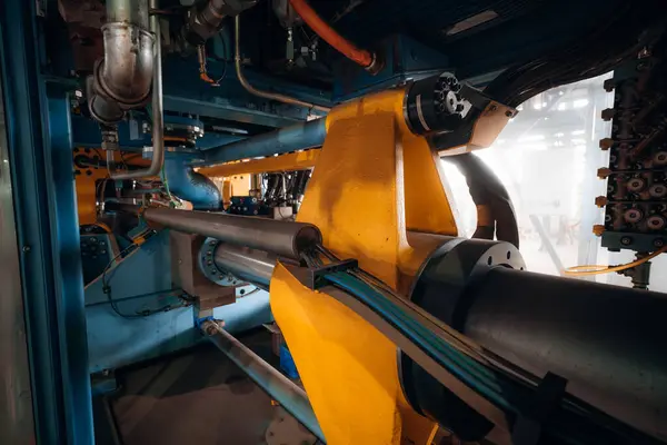 Endüstriyel makinelerin karmaşık iç çalışmalarını kapat. Hidrolik bileşenleri ve kabloları göster.