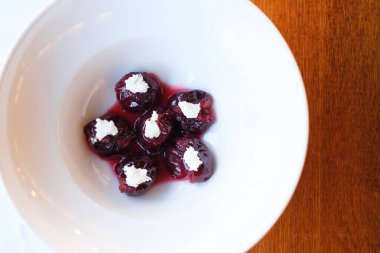 Tatlı ve lezzetli eriklerin üstüne beyaz bir tabakta bir parça krema konmuş.