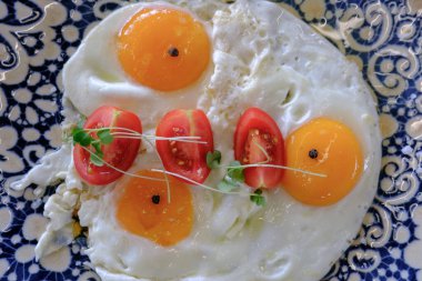 Güneşli tarafı yumurta ve vişneli domates, canlı bir kahvaltı hazırlar.
