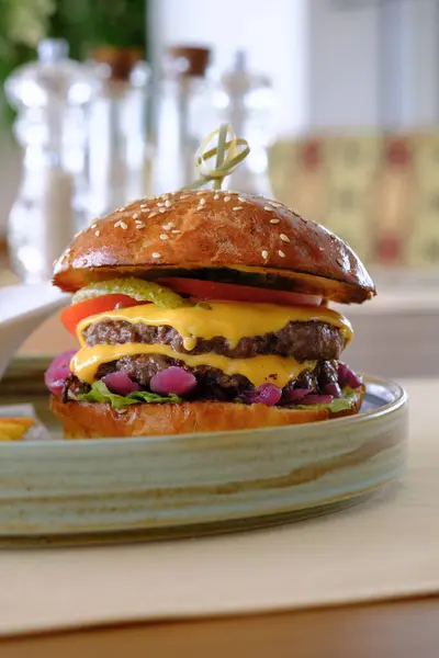 Susamlı, duble, sulu, erimiş peynirli ve taze soslu çizburger.