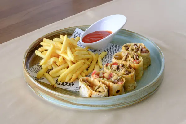 Baharatlı et, yanında altın patates kızartması ve sosla servis edilir.