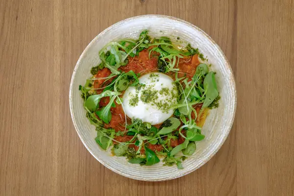 Canlı bir domates ve bitkinin üzerinde Burrata peyniri Basit ama zarif bir mutfak yaratımı