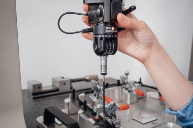 Hassas mühendislik: Bir koordinat ölçüm makinesi sondası üretilmiş bir parçayı analiz eder