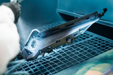 Endüstriyel bir yüzey bitiş sürecinde koruyucu bir kaplamayla boyanmış bir parça.