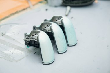 Doğal ışıklandırma altında, beyaz bir yüzey üzerinde kısmen monte edilmiş üç cihaz endüstriyel bir ortamı yansıtıyor.