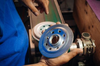 Metal işçisi, atölyedeki hassas mekanik bileşenleri inceler ve üretim endüstrisini faaliyete geçirir.