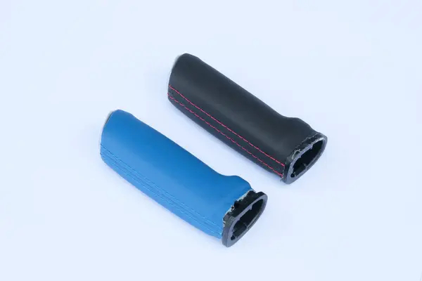 İki kabzası var: biri mavi, diğeri siyah. Beyaz arka planda kırmızı dikişli.