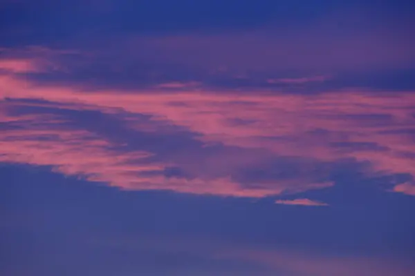 Pembe ve mor renkler akşam gökyüzünü boyar nefes kesici bir günbatımı manzarası