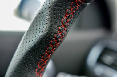 Kırmızı dikişli delinmiş deriyi kapatın. Otomotiv detayları.