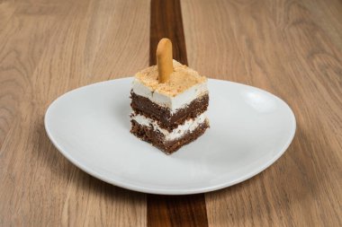 Beyaz tabakta servis edilen kurabiyeli lezzetli katmanlı pasta. Afiyet olsun.!